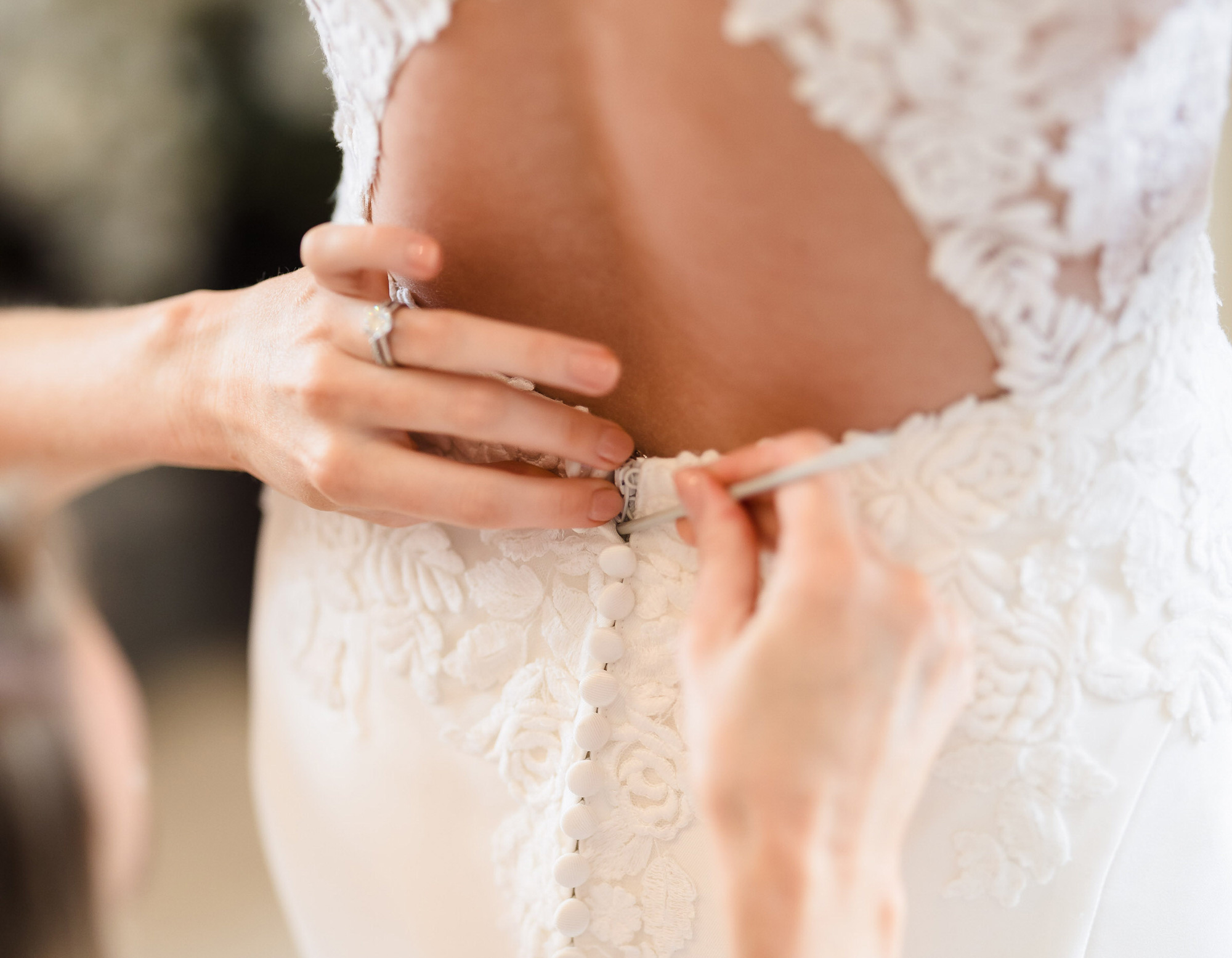 A close-up doing up a wedding dress