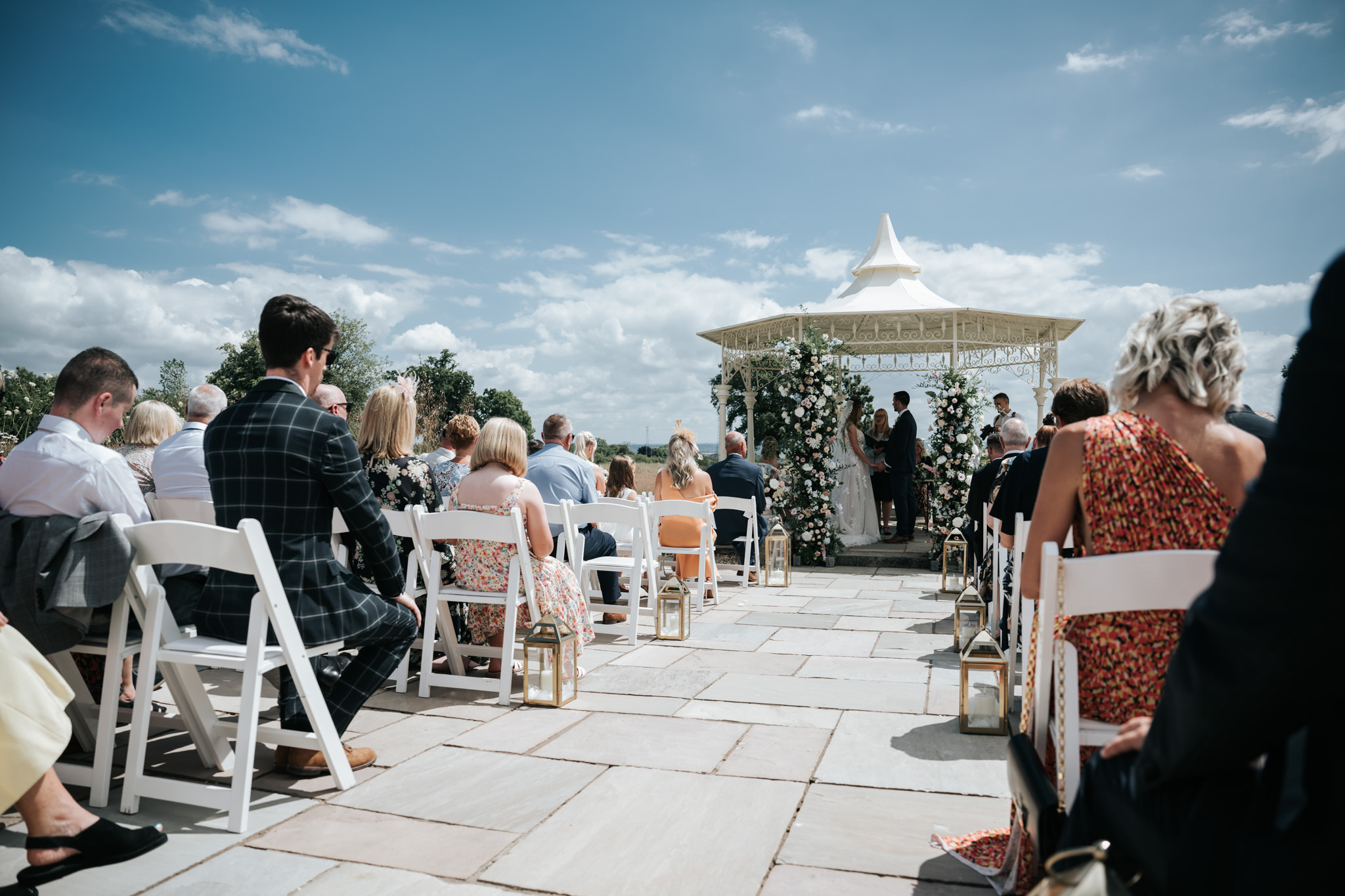 bride and groom walking down the aisle with members stood up clapping